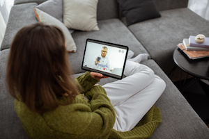 Kvinna som pratar med en läkare online med hjälp av digital surfplatta